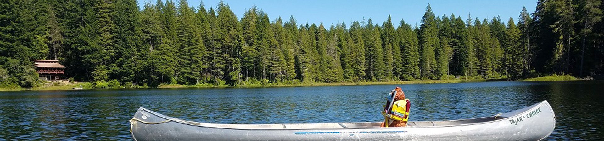  Image Description: A photo of a canoe on a lake with trees in the background.  