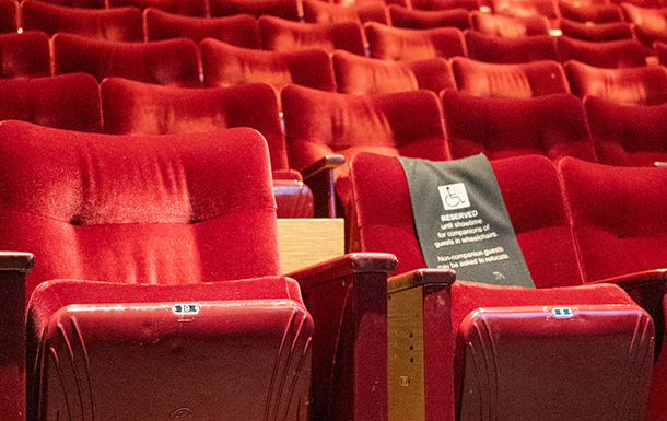 An auditorium of red theater chairs. 