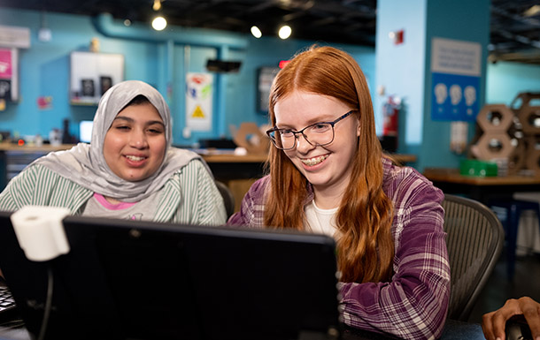 Two Girl Scouts looking at computers in excitement